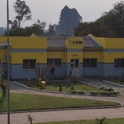Fachada de uma empresa em processo de revitalização. A estrutura está passando por pintura e reforma geral. A cor predominante da fachada é amarela, com andaimes e materiais de obra visíveis, indicando que o prédio está ficando novo