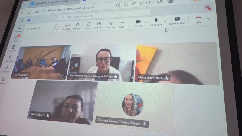 Na imagem aparece todos os conselheiros em formato online atentos a reuni&atilde;o e uma tela mostra a reuni&atilde;o presencial com o presidente Baretta e a secret&aacute;ria Cleo. Todos est&atilde;o s&eacute;rios e atentos &agrave; reuni&atilde;o